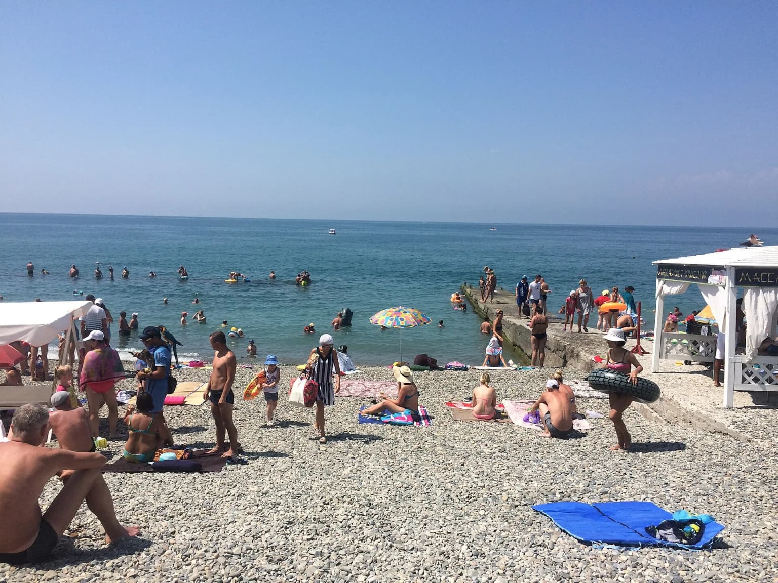 Галечный пляж Чкаловский в Адлере, Сочи, в разгар курортного сезона