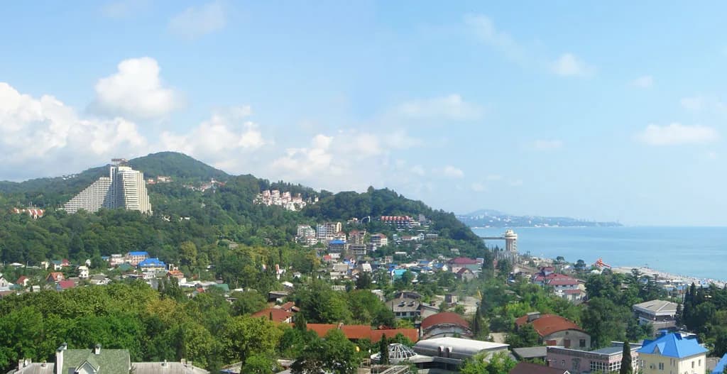 Панорама Дагомыса: посёлок на зелёных холмах у Чёрного моря, высотный корпус санатория слева